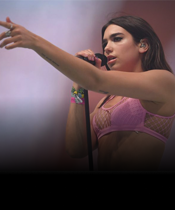 Singer Dua Lipa, singing into a microphone