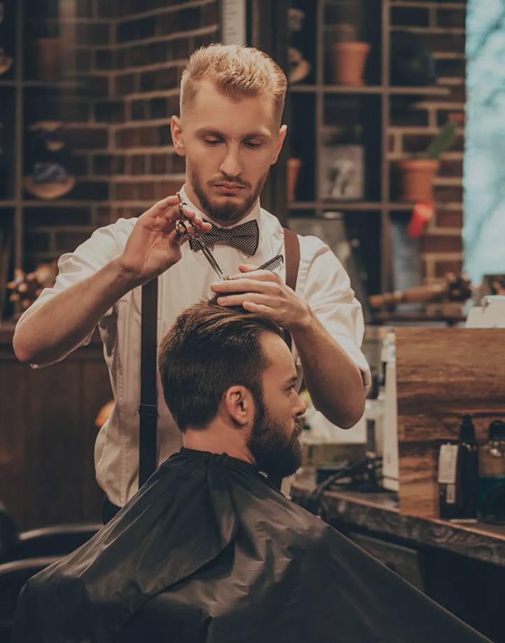 Stylish barber working on client's hair