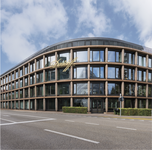 An Oettinger Davidoff, Maison Davidoff building with large glass windows on the façade that reflect the surroundings.