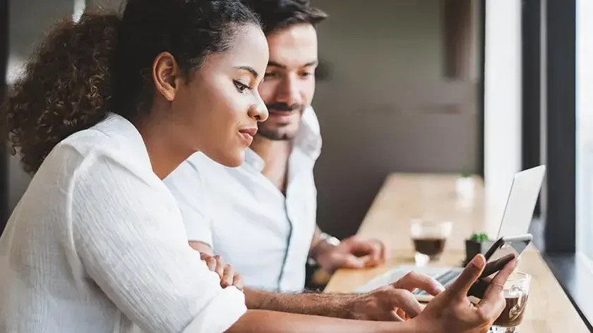 couple looking at their phones in a cafe