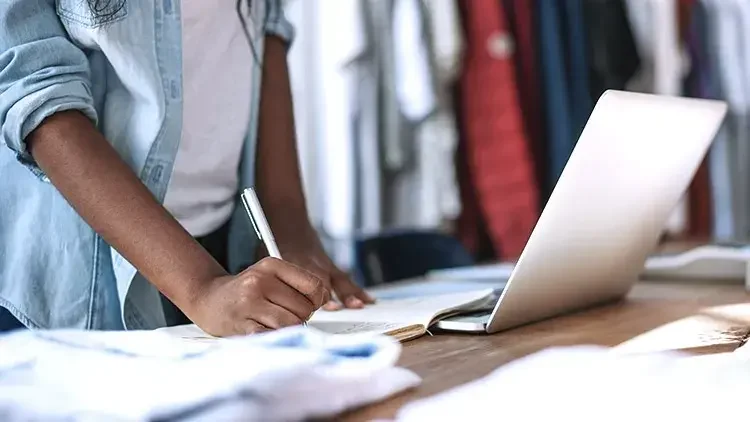 Woman taking notes on laptop-at-retail-business