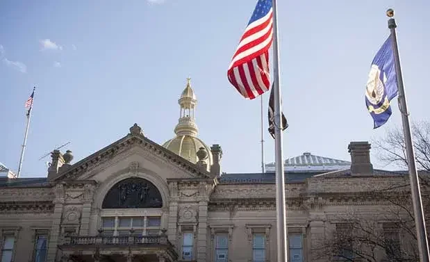 Colonnaded building with American flag and New Jersey flag flying out front