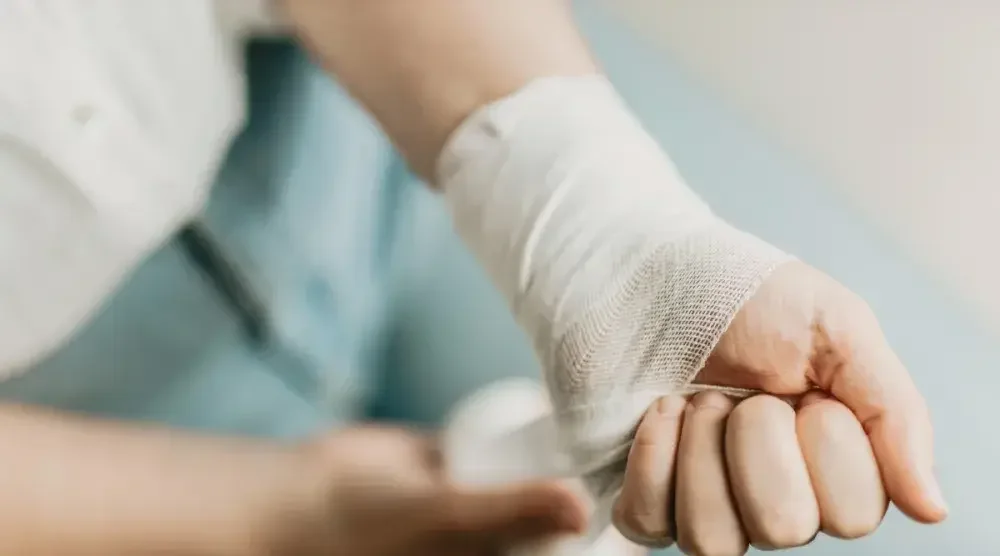 A person wraps their wrist with a bandage. You don't have to manage your dog bite incident alone; a personal injury lawyer can help.