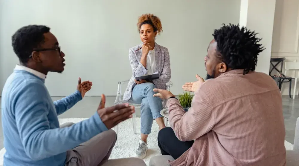 A divorce mediator watches on as a couple has a heated discussion about their divorce settlement.