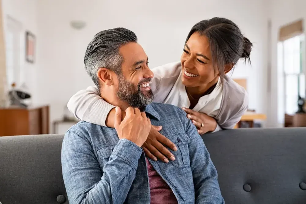 A woman hugs her fiance as they share a laugh. If you are planning to get married in Pennsylvania, consider signing a legally valid prenuptial agreement.