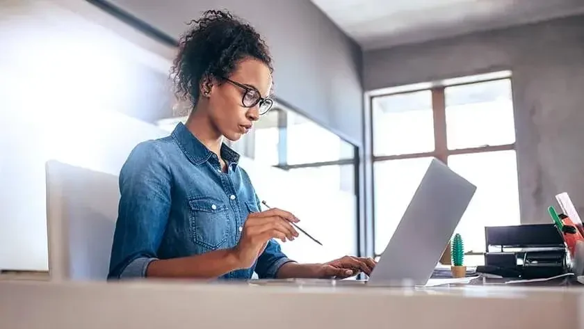 woman-concentrating-looking-at-laptop-in-office