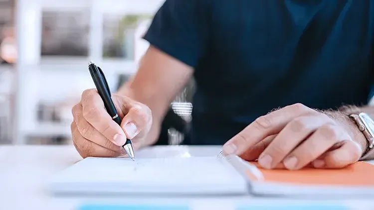 man-writing-at-desk