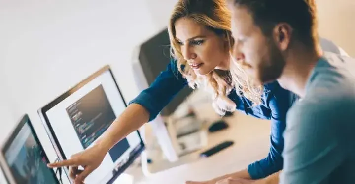 Man and woman pointing at a computer