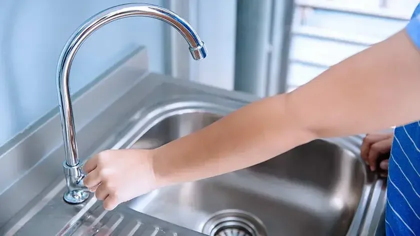 Women trying to turn on water faucet