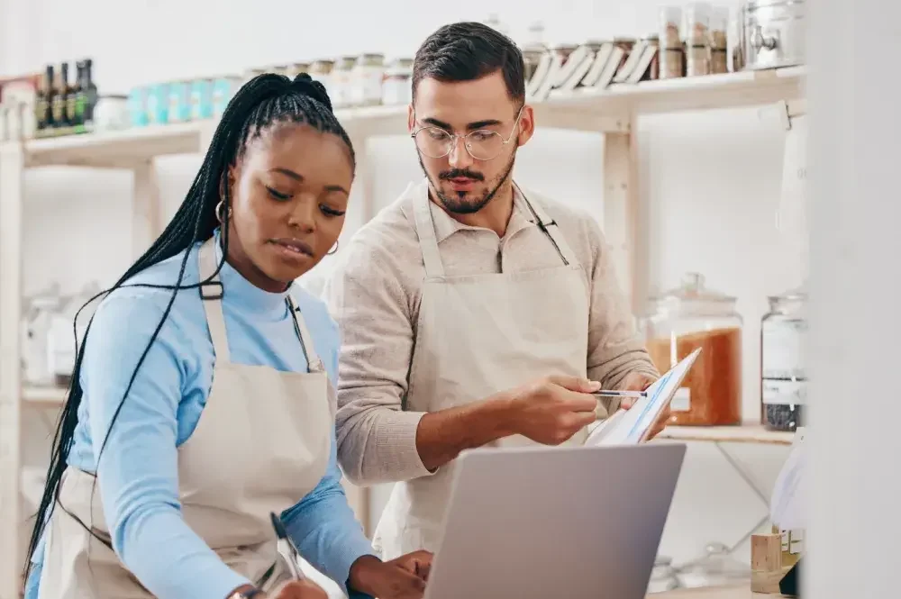 Business partners check their receipts in their spice store and discuss business formation. While corporations can issue stock, businesses structured as limited liability companies cannot.