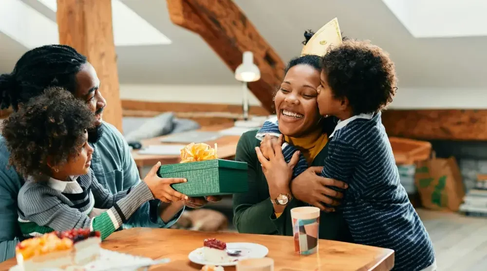 A mother celebrates her birthday with her next of kin: her husband and two young children.