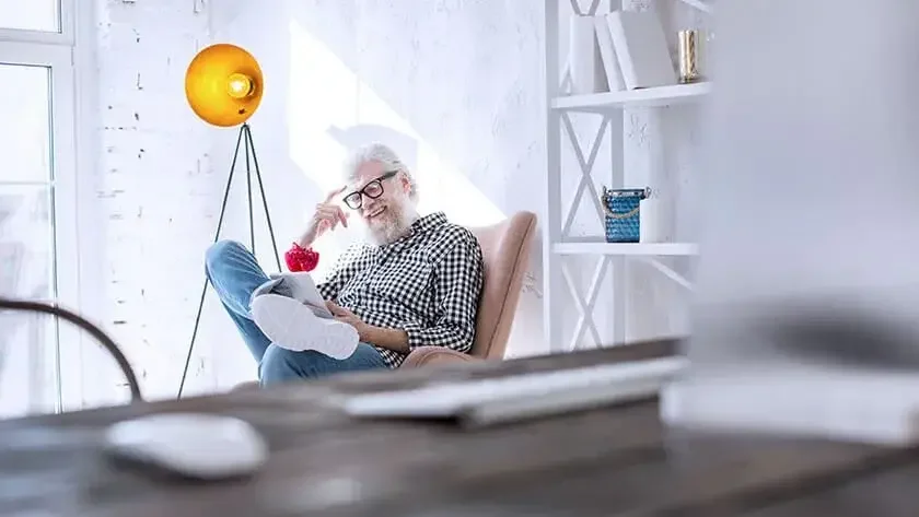 older-man-smiling-looking-at-tablet