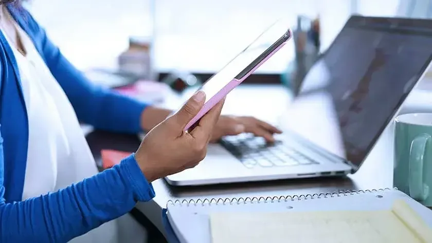 Woman on phone looking at computer