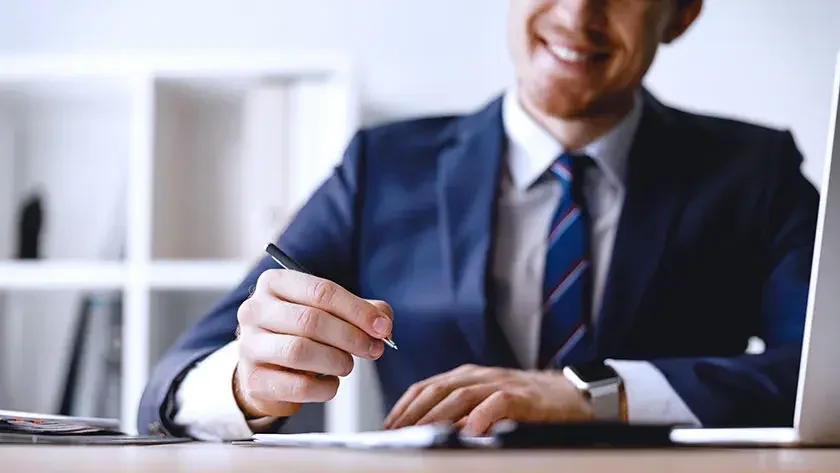 smiling-businessman-signing-document