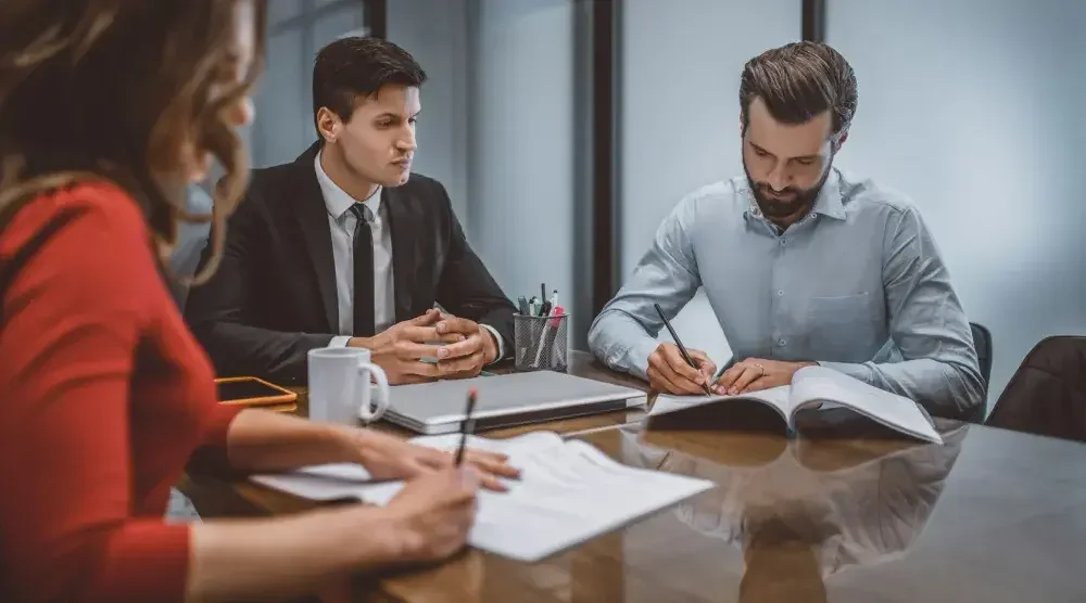 An attorney sitting between a couple at a table discussing uncontested divorce in Texas