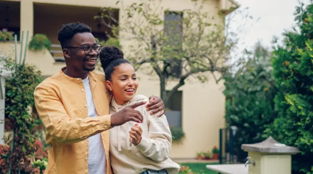 A man and woman who recently formed a domestic partnership stand in front of their condo building. registered domestic partners in California enjoy almost identical rights and responsibilities to those you'd find with a married couple.