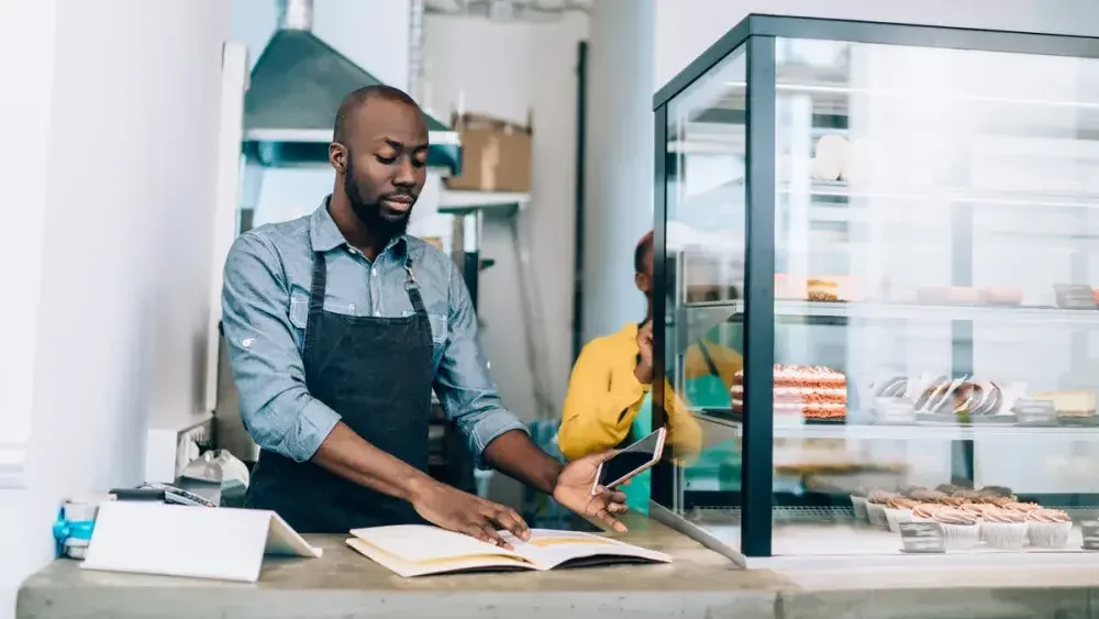 man working in a bakery calculating his taxable income 