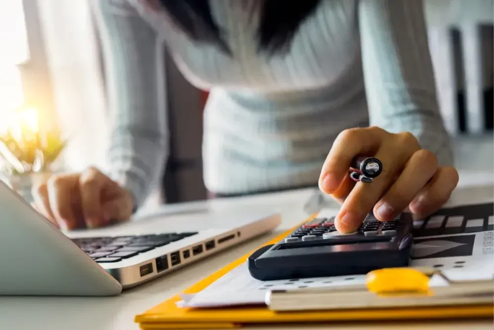 A woman uses an adding machine to determine depreciation for her business.