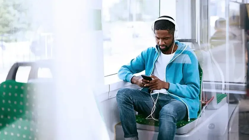 man writing music listening to headphones