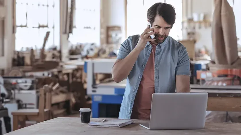 man on laptop in his work shop