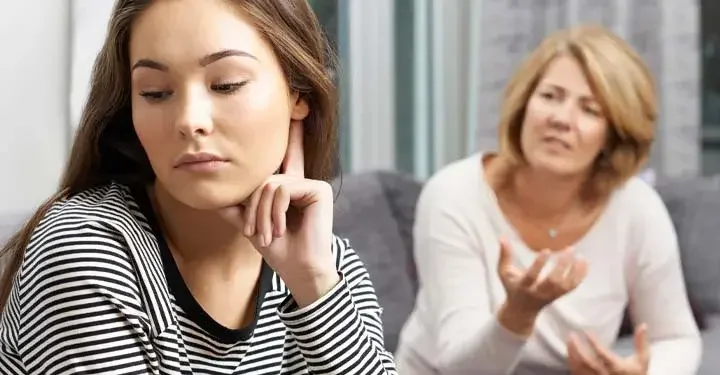 Upset teen looking away from her mother