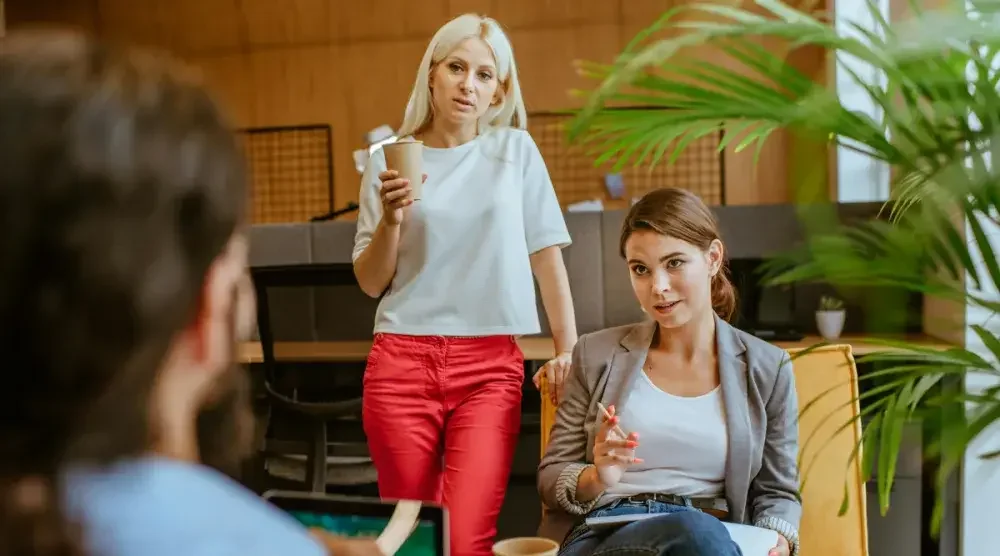 A lawyer and her client sit for divorce mediation with the client's husband.