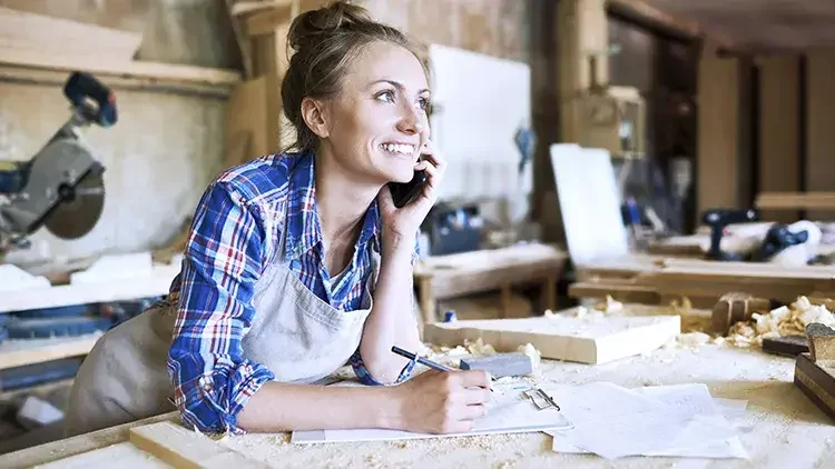 woman wearing an apron takin an order in her workshop