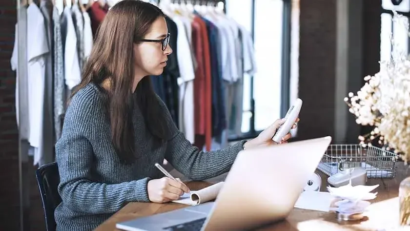 retail clothing shop owner taking notes