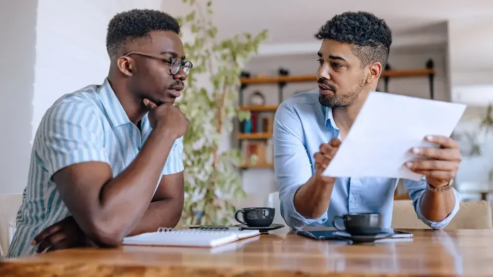 A married couple sits at their dining room table to discuss their assets and other interests they would like to include in their living trust.