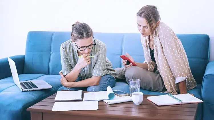 Two women looking through documents at home