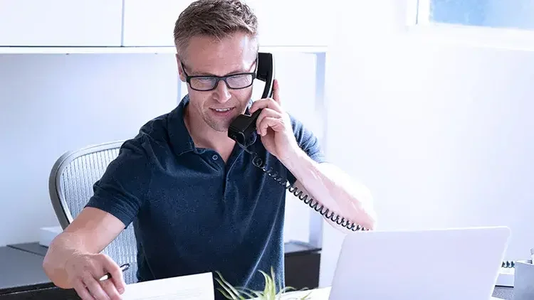 Man on phone looking at paperwork