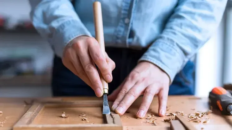 Hands sculpting shaving woodwork