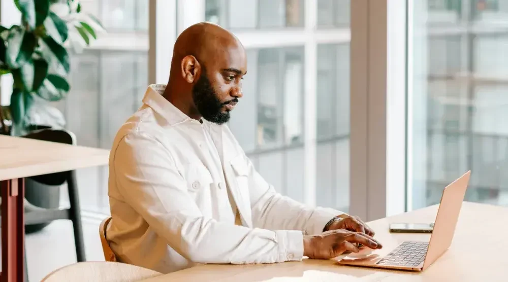 A small business owner in New York works on his laptop computer to file his biennial statement online.