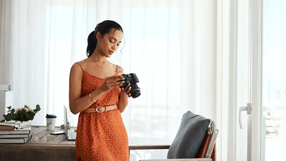 A woman looks at the back of her camera. If you have a side job, then pay taxes directly to the IRS via quarterly estimated tax payments.