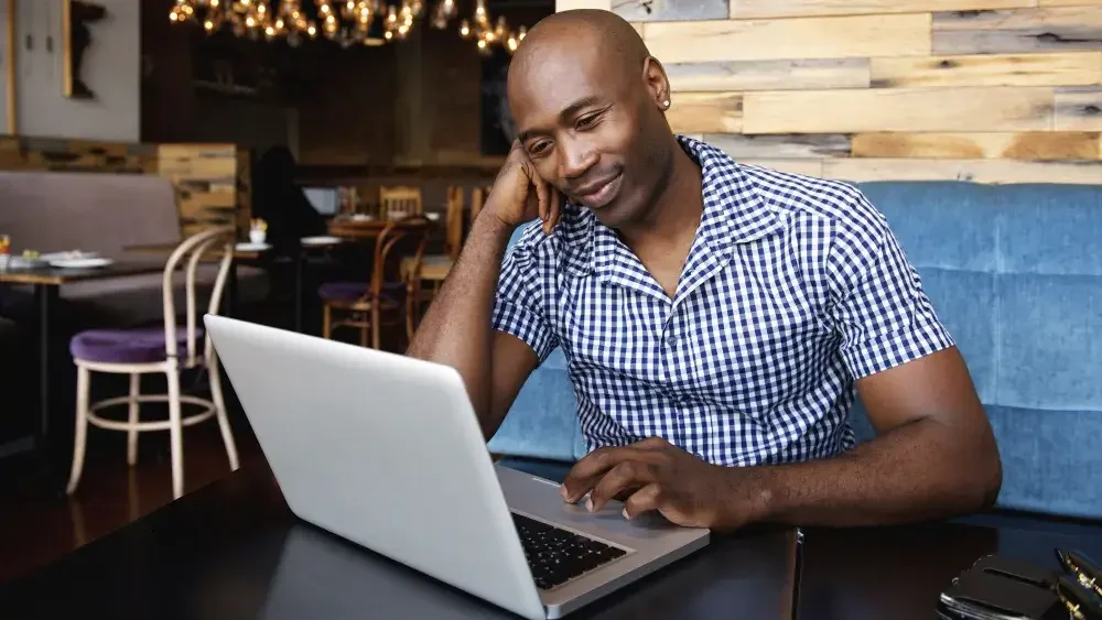 man working on laptop in restaurant 