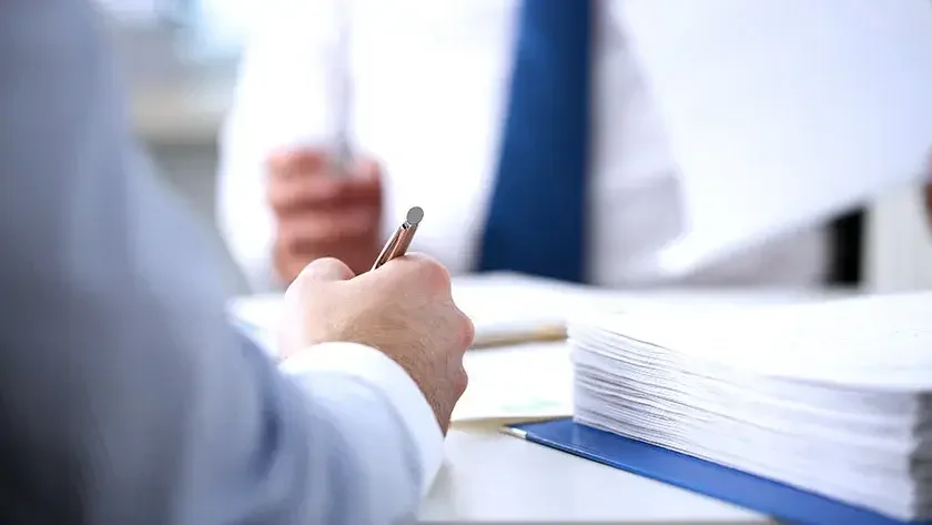 Two men signing documents