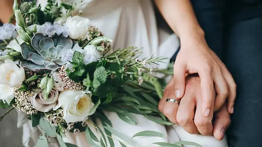 married-couple-holding-hands-bouquet