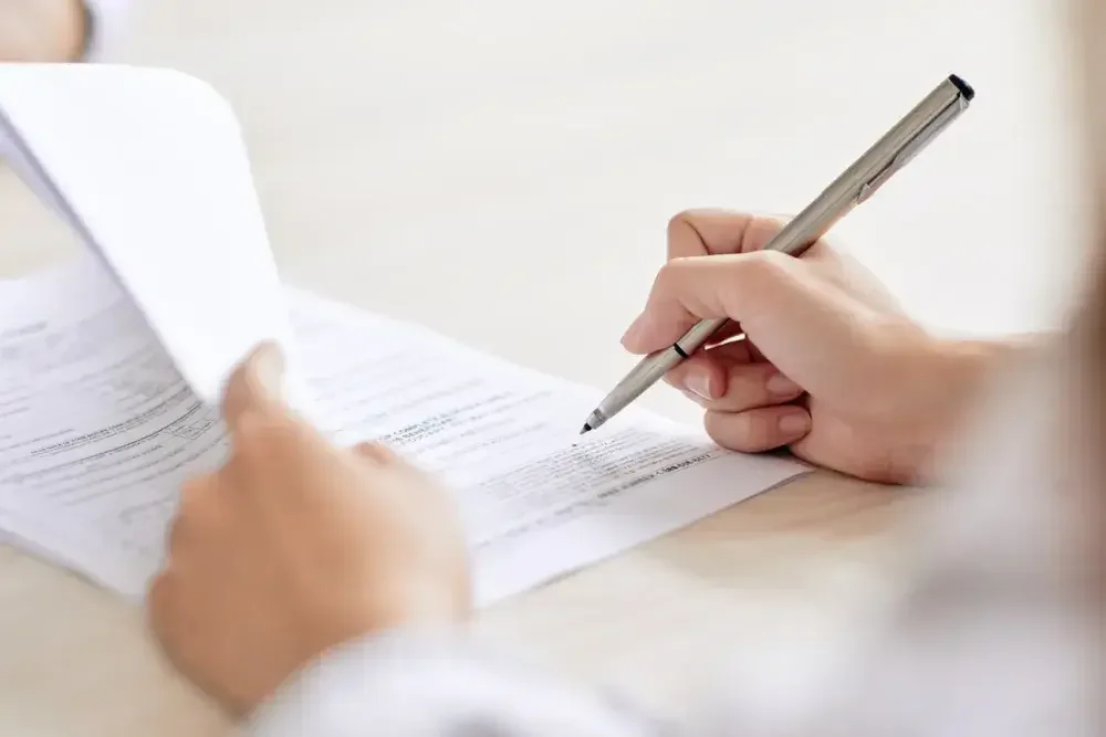 A trademark attorney signs paperwork for his client to apply for a trademark.