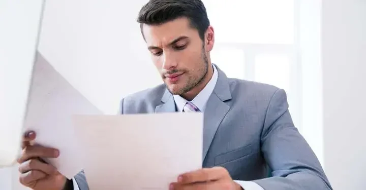 Businessman appearing confused while sifting through papers