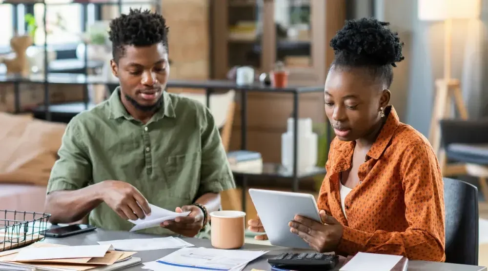 Two small business owners in Maryland sit at a table and go over paperwork. A Maryland limited liability company (LLC) is a common choice for small businesses.