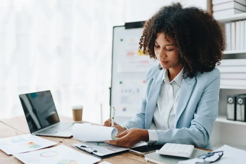 The owner of an LLC sits at her desk and fills out a Beneficial Ownership Information Report. Effective Jan. 1, 2024, the Corporate Transparency Act is intended to help law enforcement combat the use of shell companies for money laundering, terrorism, and other illegal activities.