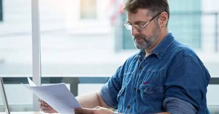 Man holding papers reading documents