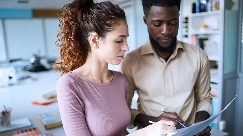 A newly married woman and man look at estate planning documents to see what needs updating.