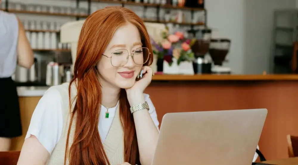 An Arizona woman sits in a cafe and researches LLC formation on her laptop.