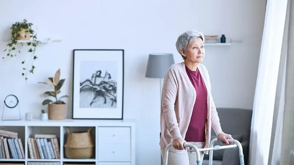 A woman uses a walker inside her home. It's best to update your will after major life events and changes in circumstances.