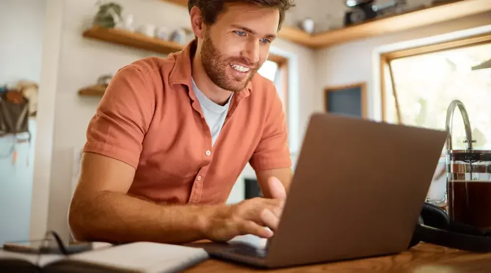 A Utah business owner sits at his desk and conducts a Utah business search on his laptop.