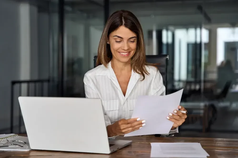 A small business owner gathers paperwork to apply for an EIN. Business owners need an EIN to set up payroll, file tax election forms, apply for a business loan, and pay business taxes to government agencies.