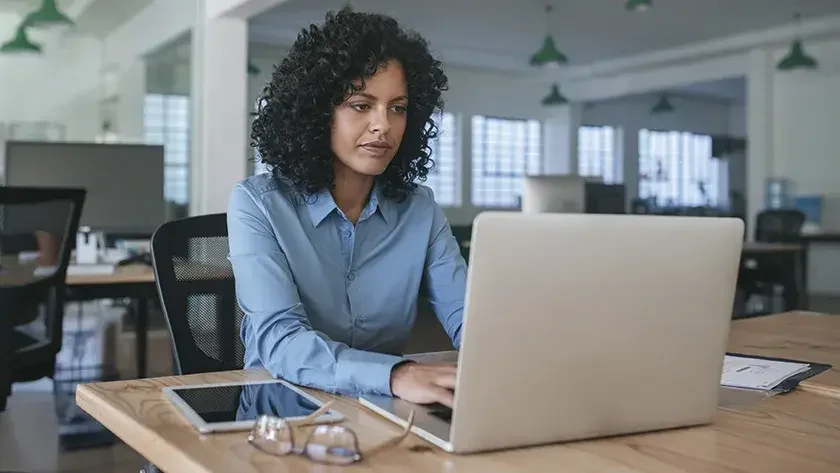 woman sitting at laptop thinking hard 