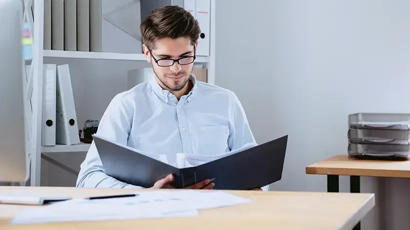 man reading paperwork in his office