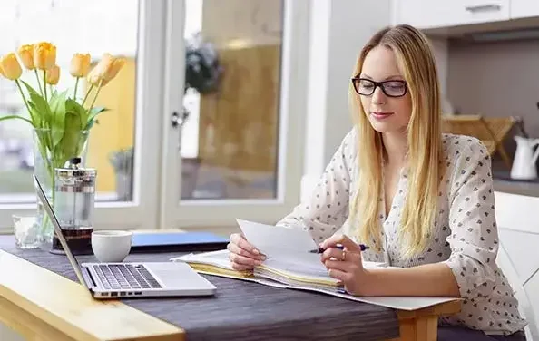 Blonde woman looking at documents in home office